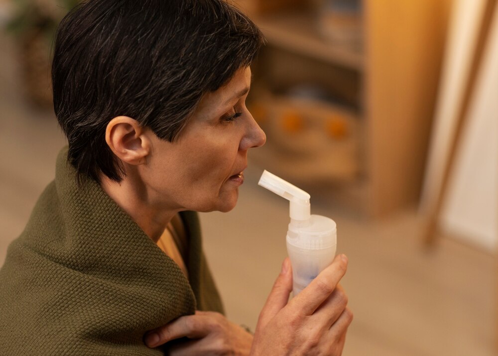 Side view woman using nebulizer